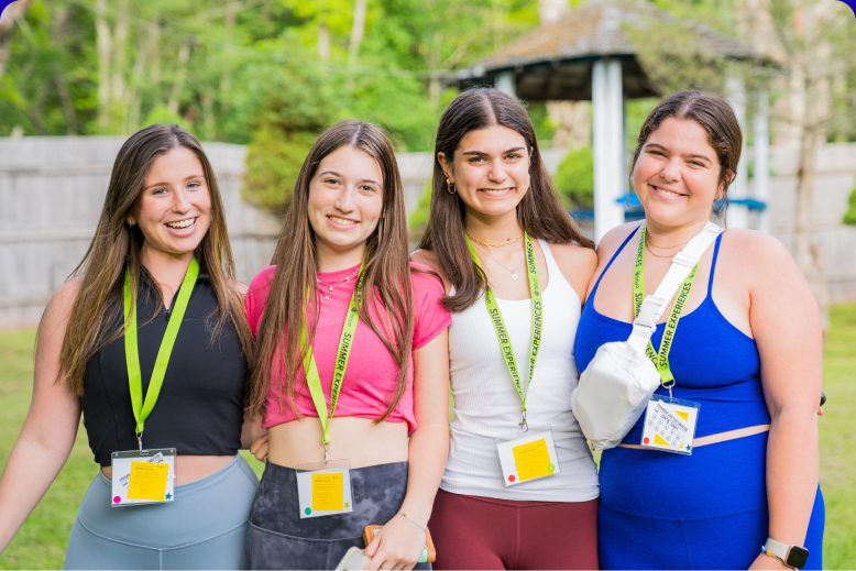 Un groupe hétéroclite de jeunes adultes sautant de joie dans un jardin verdoyant lors d'un événement communautaire.