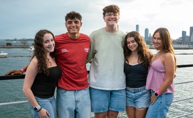Un groupe de trois parents souriants lors d'un événement communautaire