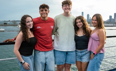 Un groupe de trois parents souriants lors d'un événement communautaire