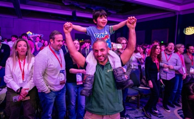 Un groupe de trois parents souriants lors d'un événement communautaire