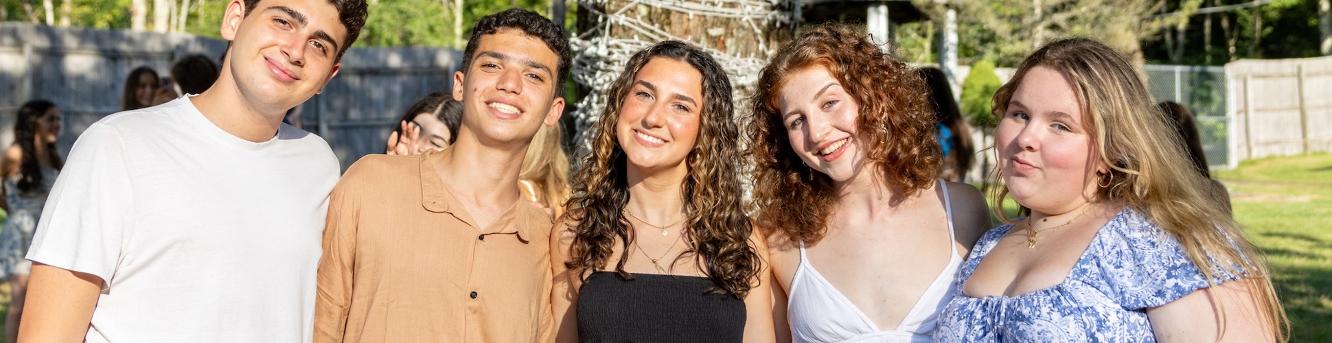 Un groupe de jeunes de tous horizons souriant lors d'un événement communautaire