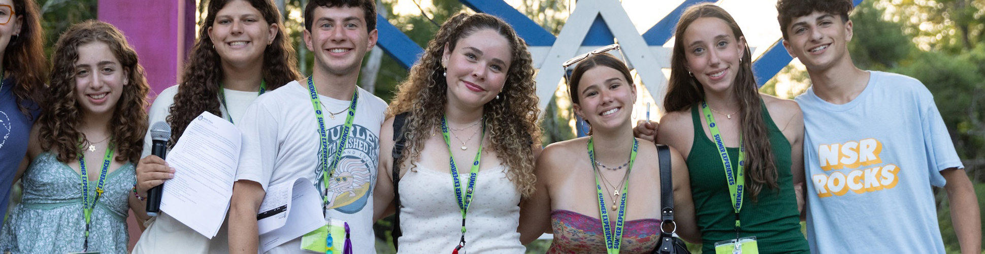 Un groupe de jeunes de tous horizons souriant lors d'un événement communautaire