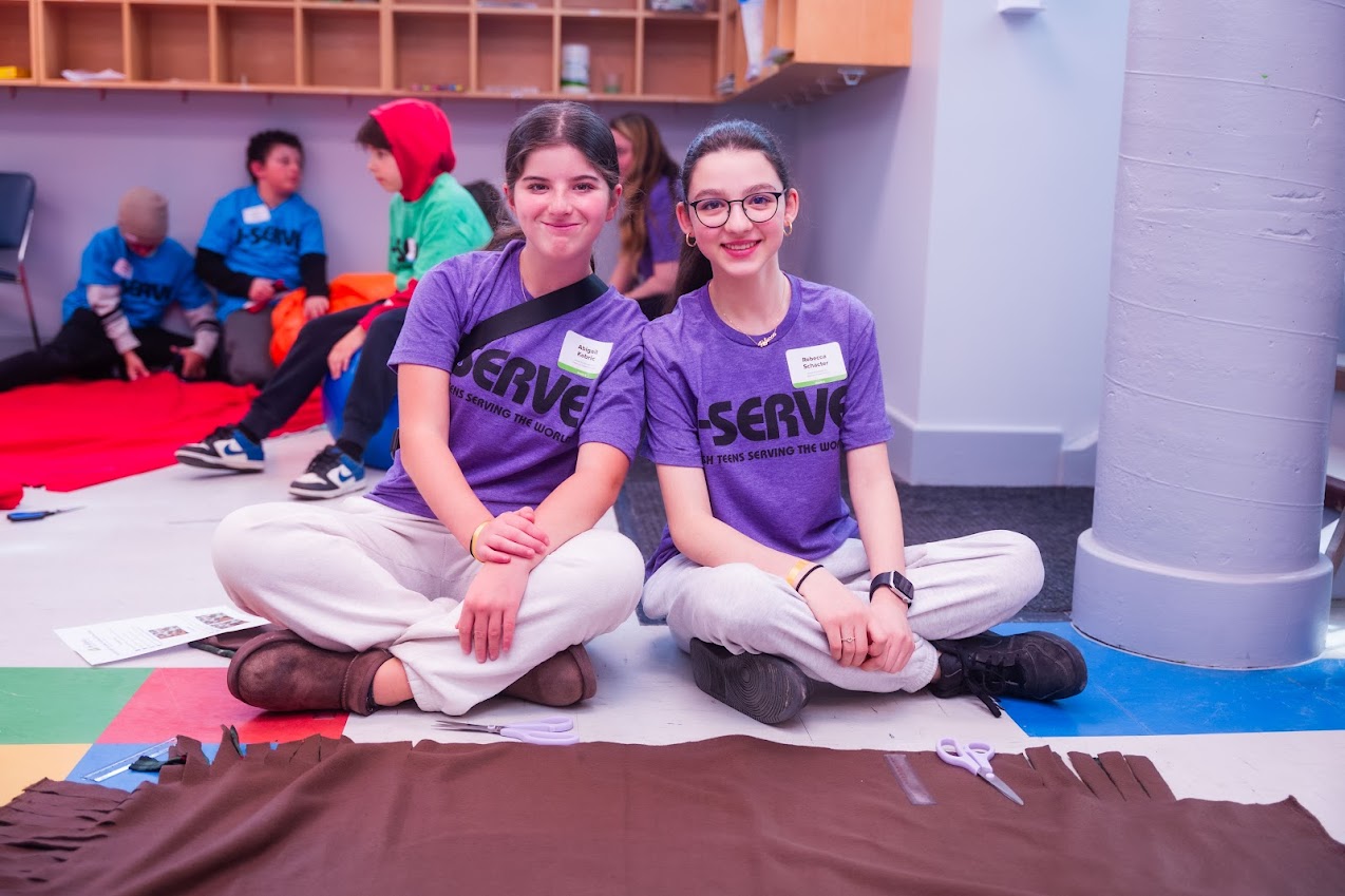 Un groupe de trois parents souriants lors d'un événement communautaire