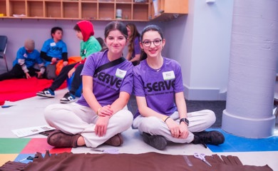 Un groupe de trois parents souriants lors d'un événement communautaire