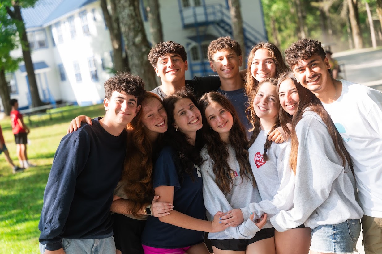Un groupe de jeunes de tous horizons souriant lors d'un événement communautaire
