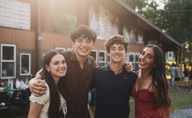 Un groupe de trois parents souriants lors d'un événement communautaire